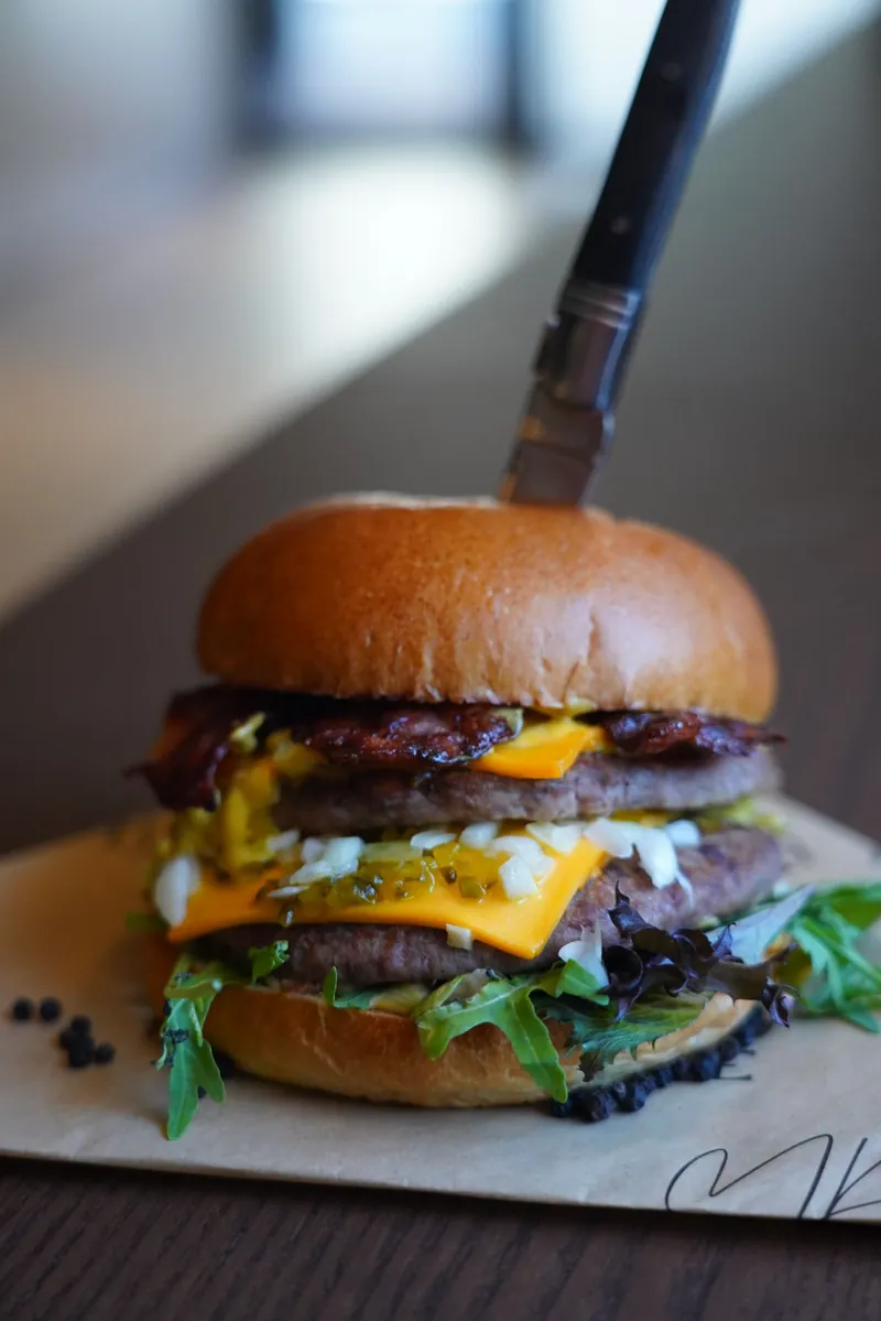 Burger van Ma Bouffe met kaas, spek, sla en een goudbruin broodje